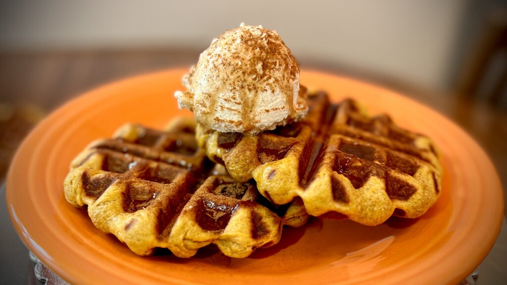 Pumpkin Waffles with syrup and whipped cream